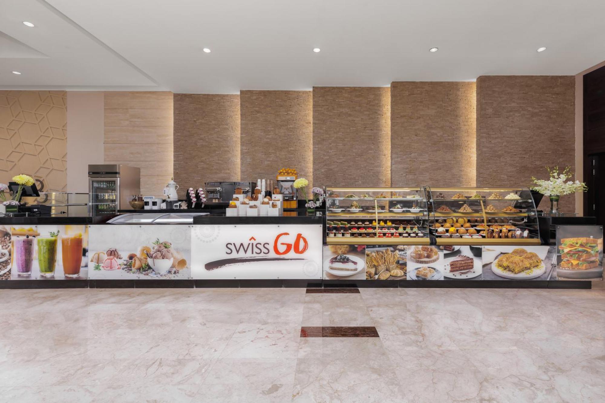 Swissotel Makkah Mecca Exterior photo The photo shows a modern café or pastry shop setup. The counter is well-organized, displaying a variety of baked goods, pastries, and desserts. There are items like cakes, cookies, and other sweet treats on display, likely inviting customers to indul