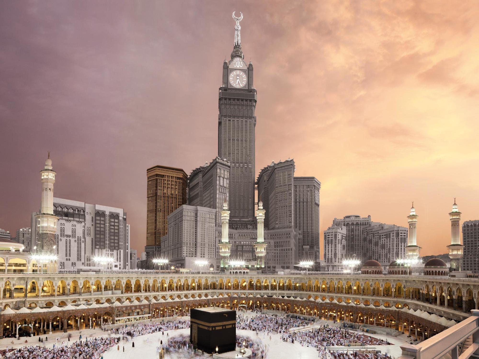 Swissotel Makkah Mecca Exterior photo The photo depicts the iconic Kaaba, located in Mecca, Saudi Arabia, surrounded by a large congregation of people performing the Hajj pilgrimage. In the background, there is a prominent clock tower building, which is part of the Abraj Al Bait complex.
